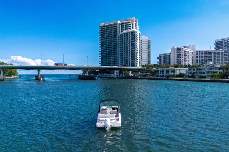 Slide: The Image of Yamaha AR250 boat on water with cityscape and bridge in background, 2021 model. - 12