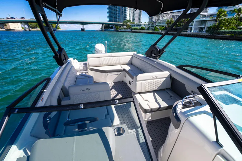 Slide: The Image of 2021 Yamaha Boats AR250 interior with seating, cruising on a sunny waterway. - 19