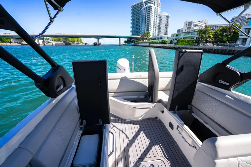 Slide: The Image of 2021 Yamaha Boats AR250 interior with open storage, overlooking waterfront cityscape. - 20
