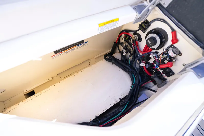 Slide: The Image of 2021 Yamaha AR250 boat wiring compartment with cables and electrical components. - 30