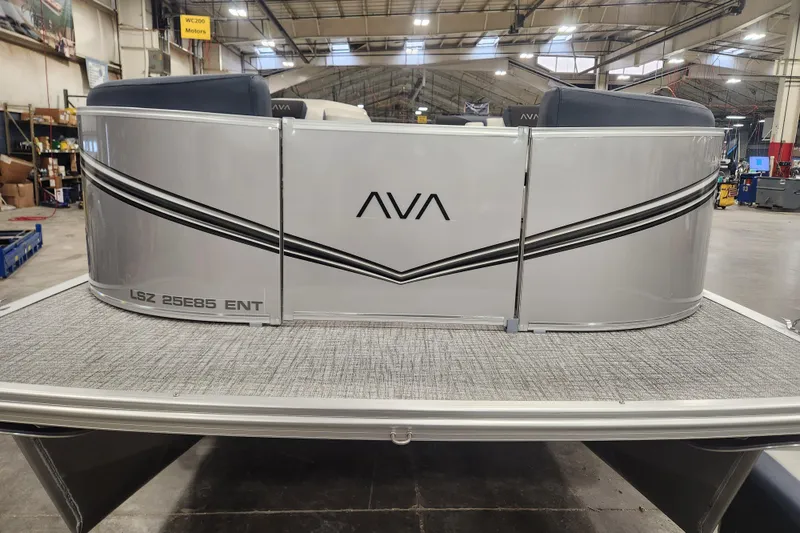 Slide: The Image of 2026 Avalon LSZ 2385 Entertainer pontoon boat with patio pad in a warehouse setting. - 14