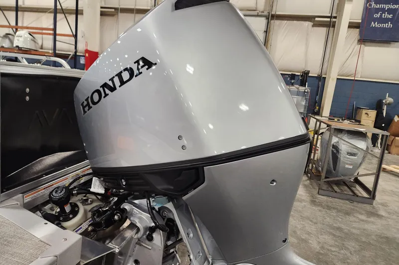 Slide: The Image of 2026 Avalon LSZ 2385 Entertainer boat with Honda outboard motor in a workshop. - 9