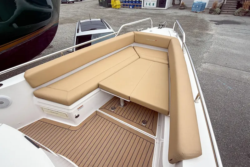 Slide: The Image of 2020 Axopar 28 Cabin with Wet Bar, featuring tan seating and teak flooring. - 10