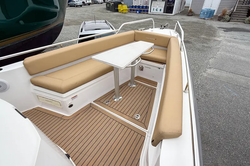 Slide: The Image of 2020 Axopar 28 Cabin with Wet Bar, featuring tan seating and a sleek table. - 12