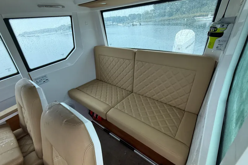 Slide: The Image of Interior of 2020 Axopar 28 Cabin with Wet Bar, featuring beige quilted seating. - 14