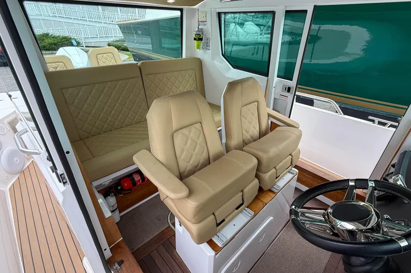 Slide: The Image of 2020 Axopar 28 Cabin with Wet Bar, featuring luxurious beige seating and modern interior design. - 15