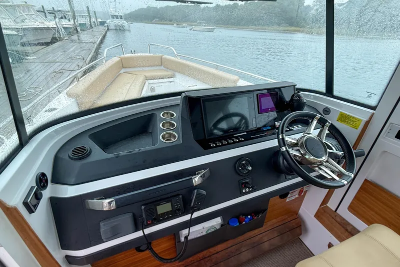 Slide: The Image of 2020 Axopar 28 Cabin with Wet Bar, featuring modern helm and spacious seating. - 16