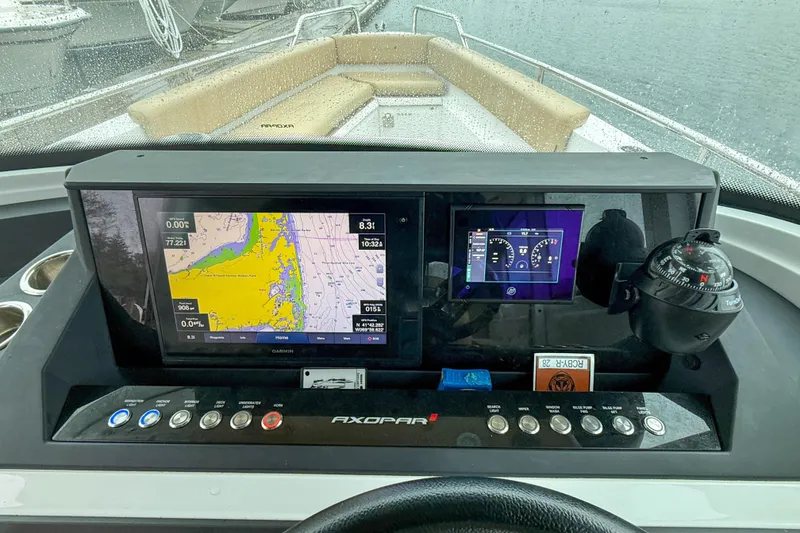 Slide: The Image of Dashboard of 2020 Axopar 28 Cabin with navigation screens and compass. - 18