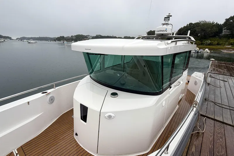 Slide: The Image of 2020 Axopar 28 Cabin with Wet Bar docked on a serene waterfront. - 19