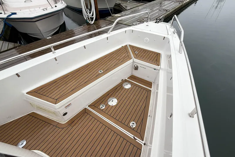 Slide: The Image of 2020 Axopar 28 Cabin boat with wet bar, featuring sleek wooden deck design. - 23
