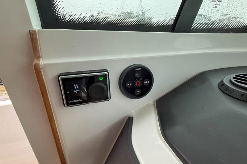 Slide: The Image of 2020 Axopar 28 Cabin dashboard controls with Webasto and Fusion systems. - 25