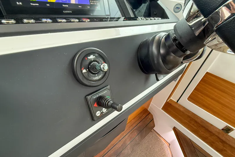 Slide: The Image of Control panel of 2020 Axopar 28 Cabin with Wet Bar, featuring steering wheel and navigation controls. - 26