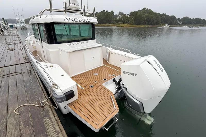 Slide: The Image of 2020 Axopar 28 Cabin with Wet Bar, docked, featuring Mercury outboard engine. - 4