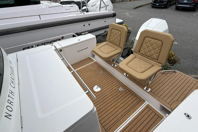 Slide: The Image of 2020 Axopar 28 Cabin with Wet Bar, featuring tan seats and teak flooring. - 7