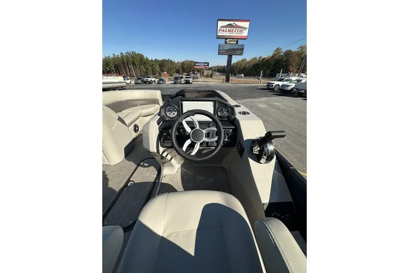 Slide: The Image of 2026 Manitou 23 Encore RF boat interior with steering wheel and dashboard controls. - 10