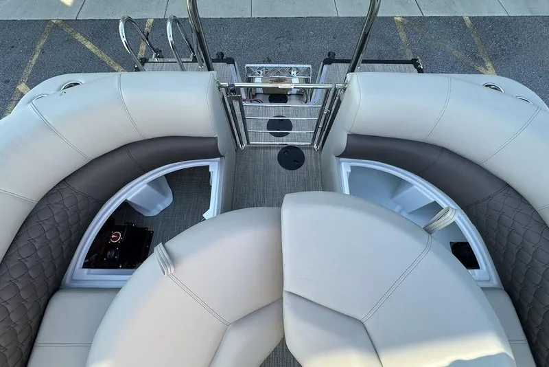 Slide: The Image of 2026 Manitou 23 Encore RF boat interior with plush seating and storage compartments. - 7