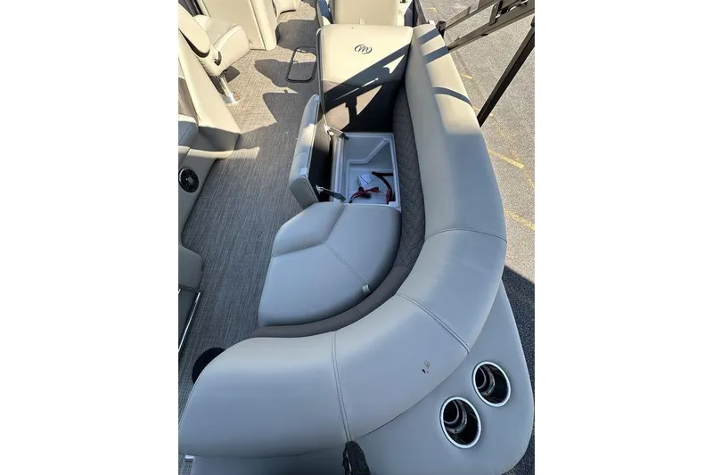 Slide: The Image of 2026 Manitou 23 Encore RF boat interior with gray seating and storage compartment. - 9