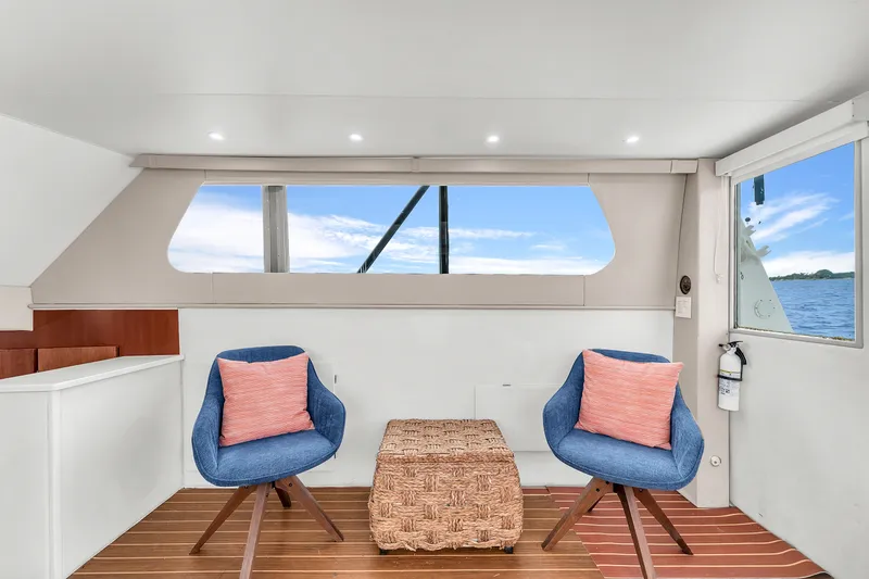 Slide: The Image of Interior of 1978 Hatteras 42 Convertible yacht with blue chairs and ocean view. - 14
