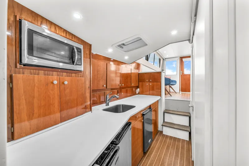 Slide: The Image of 1978 Hatteras 42 Convertible yacht interior with modern kitchen and wooden cabinetry. - 15