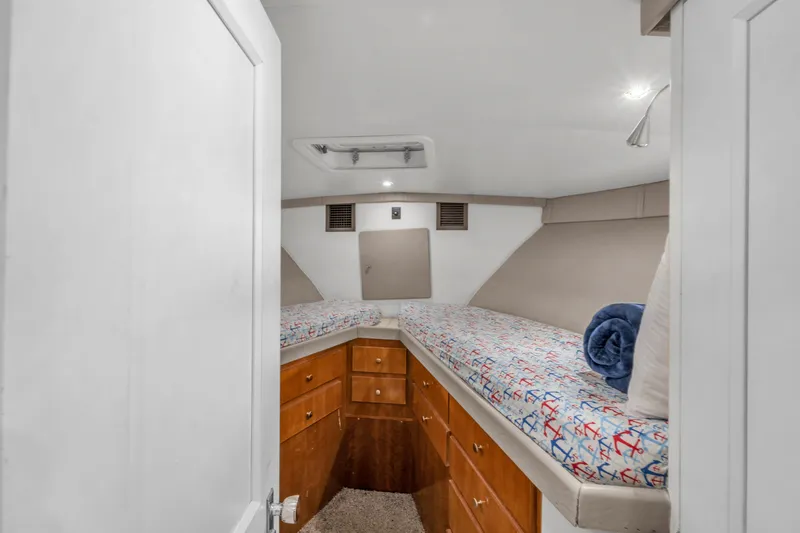 Slide: The Image of 1978 Hatteras 42 Convertible cabin with twin beds and wooden storage drawers. - 19