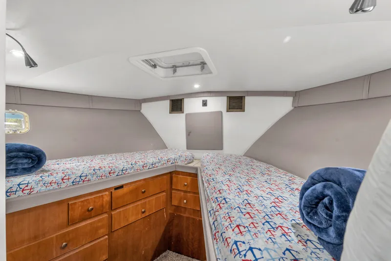 Slide: The Image of 1978 Hatteras 42 Convertible cabin with twin beds and anchor-themed bedding. - 20