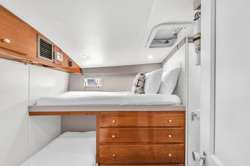 Slide: The Image of 1978 Hatteras 42 Convertible cabin with bunk beds and wooden storage drawers. - 21