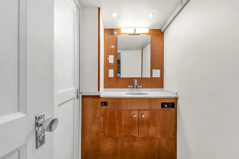Slide: The Image of 1978 Hatteras 42 Convertible bathroom with wooden vanity, mirror, and modern fixtures. - 25