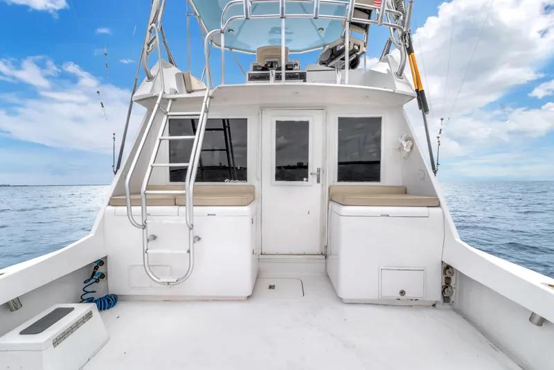 Slide: The Image of 1978 Hatteras 42 Convertible boat deck with ladder, ocean view, and clear sky. - 27