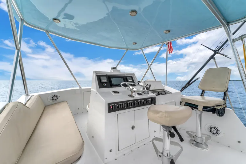 Slide: The Image of 1978 Hatteras 42 Convertible yacht helm with ocean view, featuring modern controls and seating. - 30