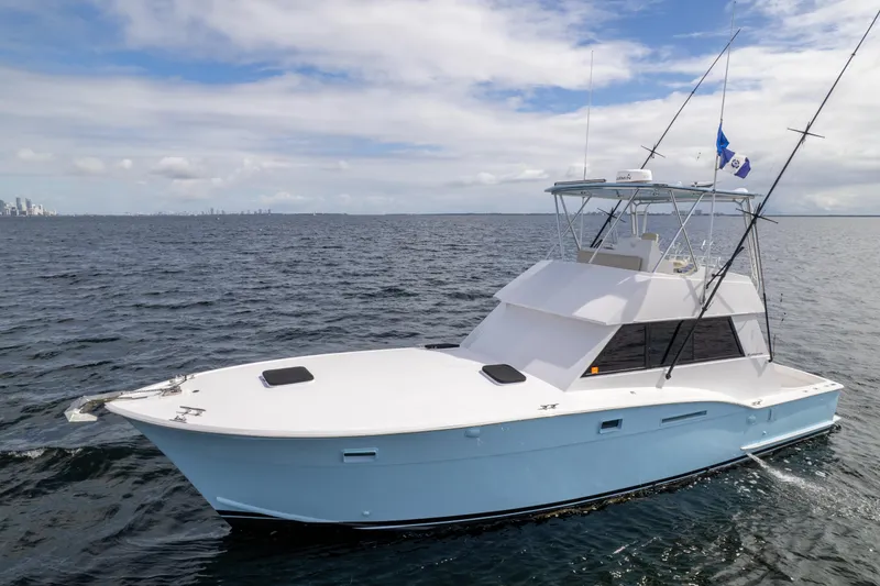 Slide: The Image of 1978 Hatteras 42 Convertible yacht cruising on open water under a partly cloudy sky. - 7