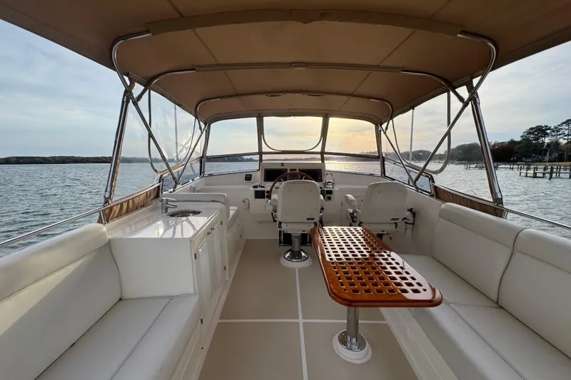 Slide: The Image of 2011 Grand Banks 47 Heritage EU yacht interior with seating and helm, overlooking serene waters. - 27