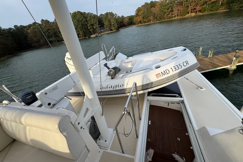 Slide: The Image of 2011 Grand Banks 47 Heritage EU yacht with tender on deck, docked by a serene lake. - 37