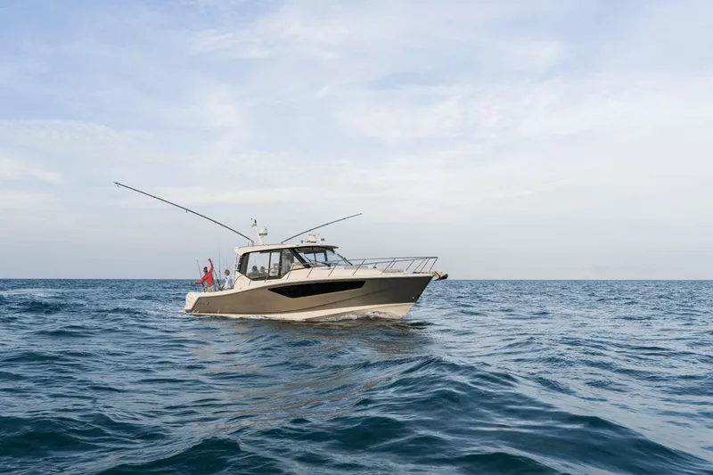 Slide: The Image of A 2027 Boston Whaler 405 Conquest cruising on calm waters under a cloudy sky. - 19