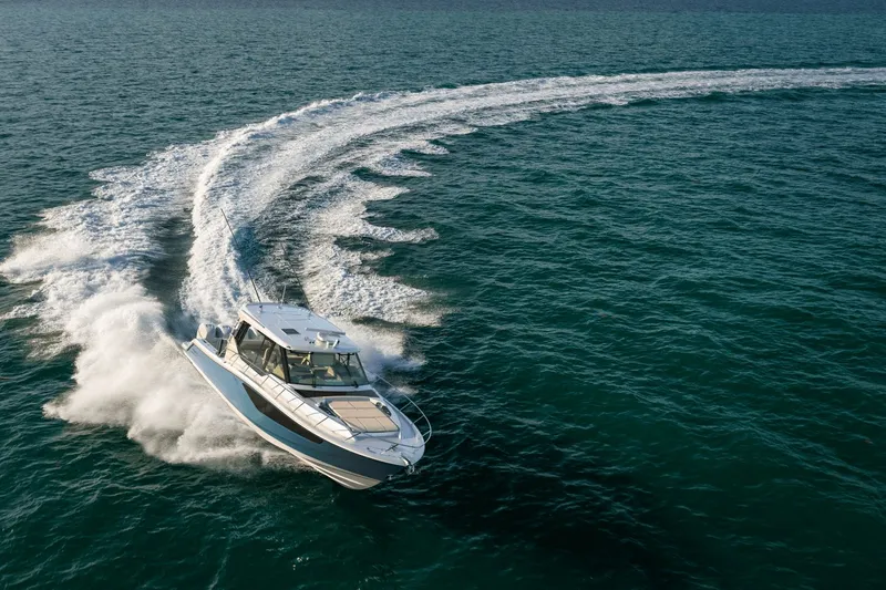 Slide: The Image of A 2027 Boston Whaler 405 Conquest speeds across open water, leaving a trail of white wake. - 7