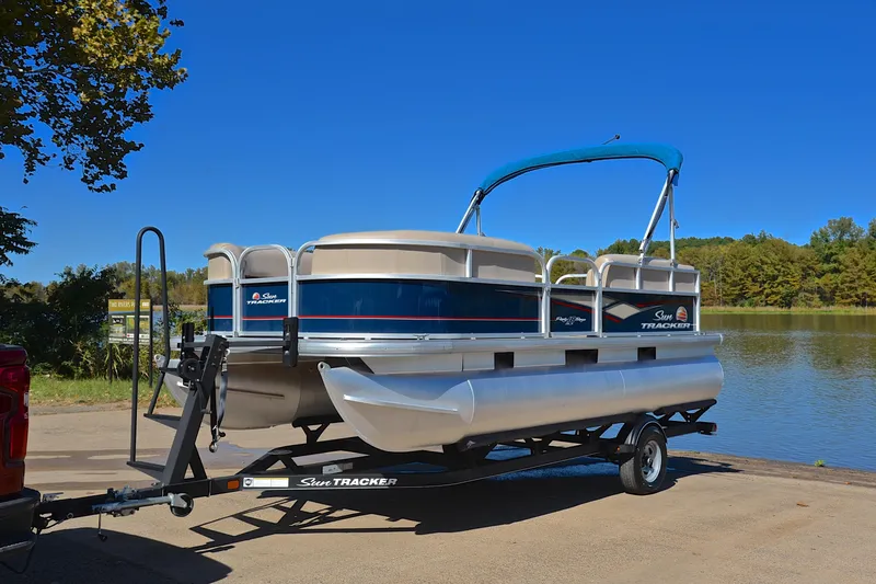 Slide: The Image of 2019 Sun Tracker Party Barge 18 DLX pontoon boat on trailer by a lake. - 10