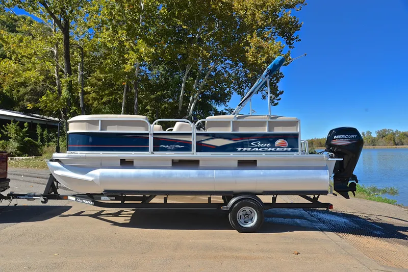 Slide: The Image of 2019 Sun Tracker Party Barge 18 DLX pontoon boat on trailer by a lake. - 11