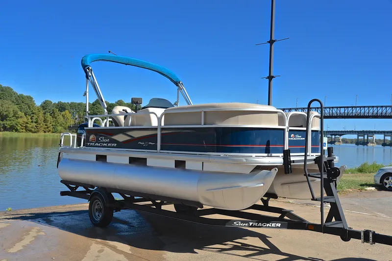 Slide: The Image of 2019 Sun Tracker Party Barge 18 DLX pontoon boat on trailer by a lake. - 16