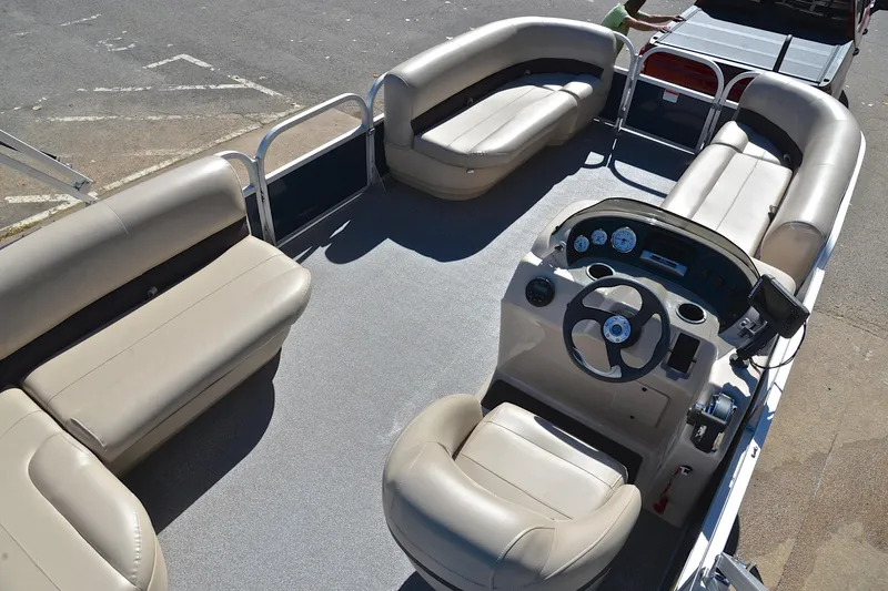 Slide: The Image of 2019 Sun Tracker Party Barge 18 DLX pontoon boat interior with beige seating and steering console. - 19