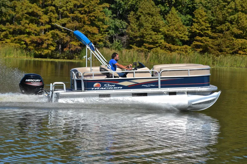 Slide: The Image of 2019 Sun Tracker Party Barge 18 DLX pontoon boat cruising on a lake. - 4