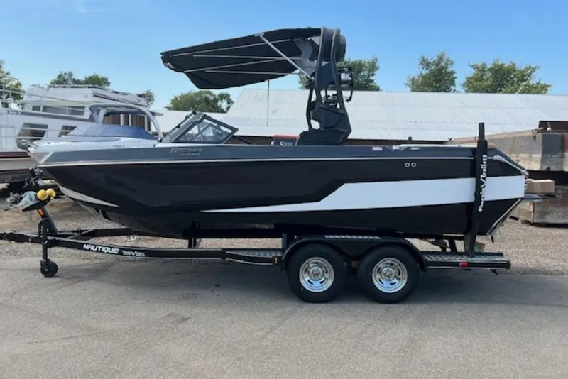 The Image of 2026 Nautique Super Air Nautique GS22 boat on trailer, black and white design. - 1