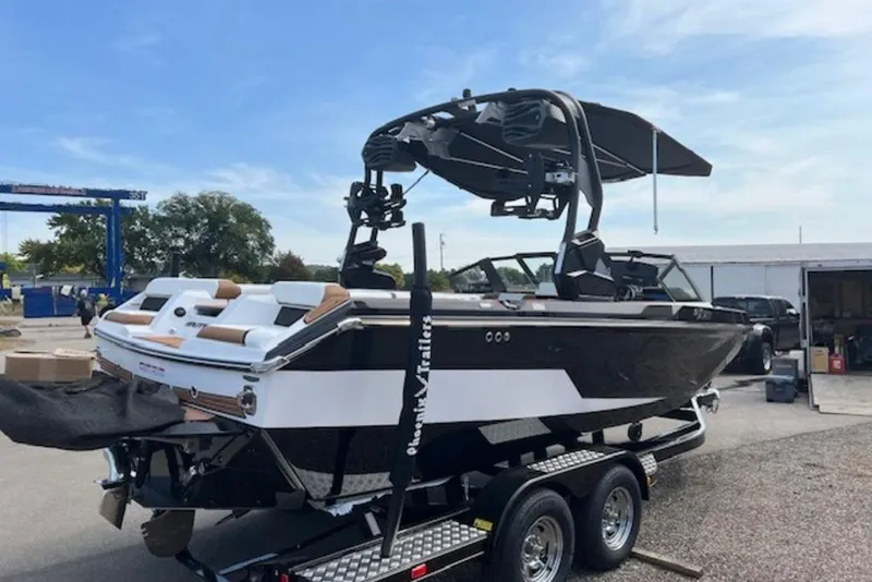 Slide: The Image of 2026 Nautique Super Air Nautique GS22 boat on trailer, black and white design, outdoor setting. - 6