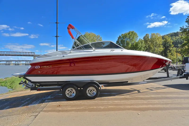 Slide: The Image of 2007 Cobalt 232 boat on trailer by river, under clear blue sky. - 12