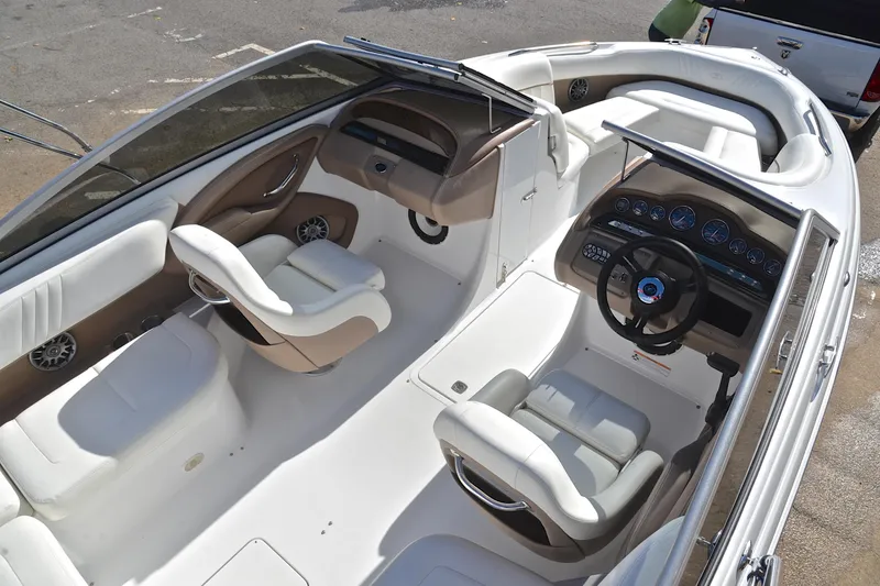 Slide: The Image of 2007 Cobalt 232 boat interior with white and beige seating, dashboard, and steering wheel. - 16