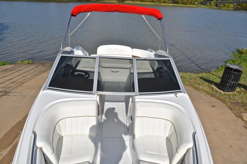 Slide: The Image of 2007 Cobalt 232 boat with red canopy, docked by a serene lake. - 17