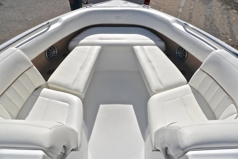 Slide: The Image of 2007 Cobalt 232 boat interior with white cushioned seating and built-in speakers. - 18