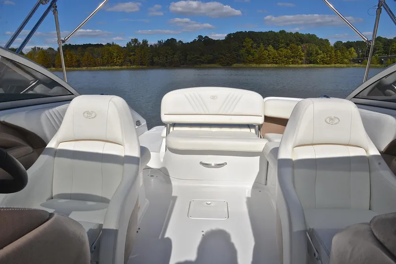 Slide: The Image of Interior of a 2007 Cobalt 232 boat with white seating, overlooking a serene lake. - 19