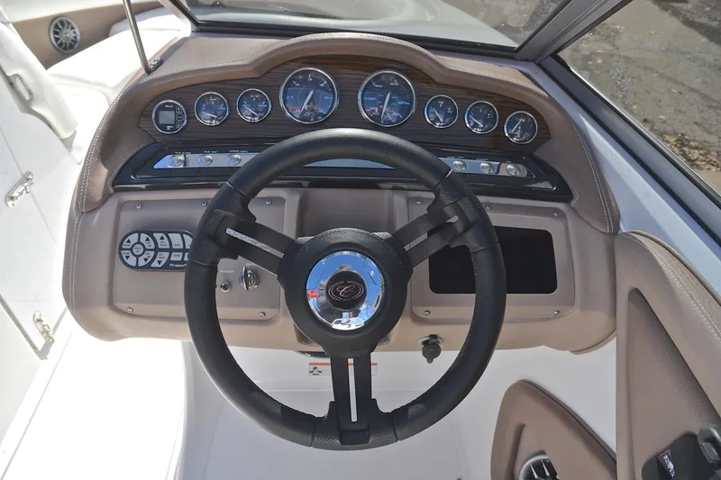 Slide: The Image of Steering wheel and dashboard of a 2007 Cobalt 232 boat, featuring gauges and controls. - 23