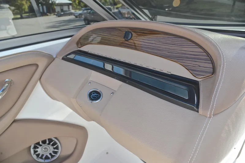 Slide: The Image of 2007 Cobalt 232 boat interior dashboard with wood accents and speaker detail. - 25