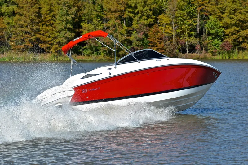 Slide: The Image of 2007 Cobalt 232 boat cruising on a lake with a vibrant red hull. - 5