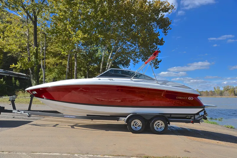 Slide: The Image of 2007 Cobalt 232 boat on trailer by a lake, under clear blue sky. - 8